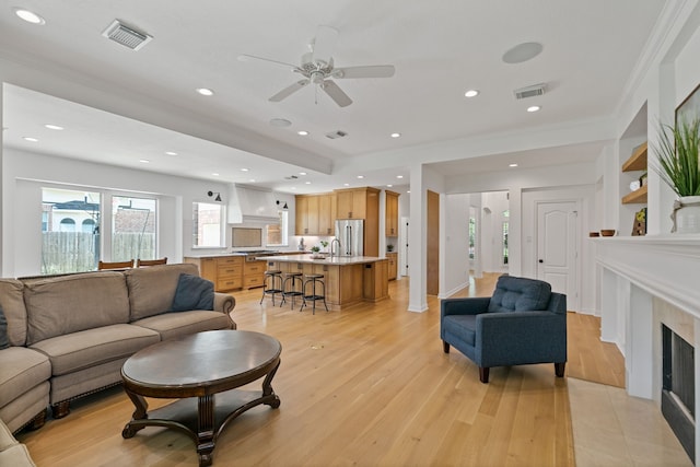 13911 Falcon Heights Dr, Cypress, TX 77429 - living area featuring light wood finished floors, a fireplace, a ceiling fan, crown molding, and recessed lighting