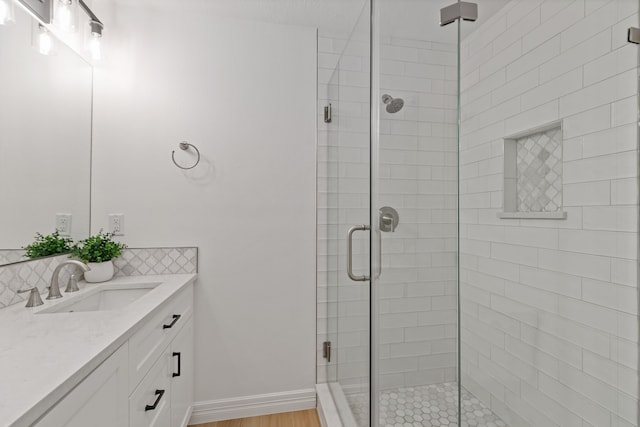 13911 Falcon Heights Dr, Cypress, TX 77429 - full bathroom featuring a stall shower, vanity, decorative backsplash, baseboards, and wood finished floors