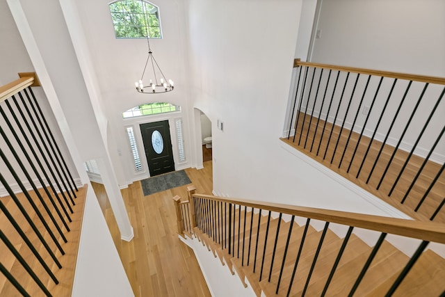 13911 Falcon Heights Dr, Cypress, TX 77429 - entryway with wood finished floors, stairway, a chandelier, a towering ceiling, and arched walkways