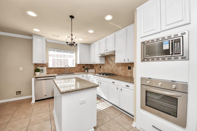22611 Bucktrout Ln, Katy, TX 77449 - kitchen with appliances with stainless steel finishes, a sink, under cabinet range hood, a center island, and white cabinetry