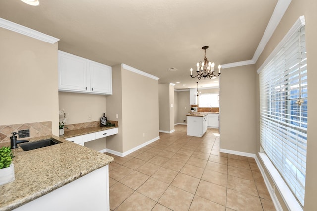 22611 Bucktrout Ln, Katy, TX 77449 - kitchen with a sink, a chandelier, ornamental molding, white cabinets, and light tile patterned flooring