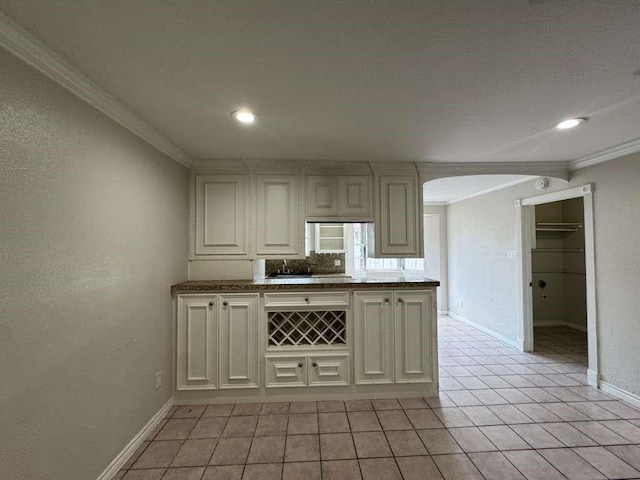 11111 Sagecrest Ln, Houston, TX 77089 - kitchen with crown molding, baseboards, arched walkways, light tile patterned flooring, and recessed lighting