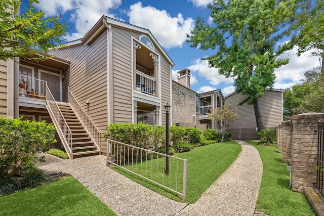 1860 White Oak Dr Unit 246, Houston, TX 77009 - view of home's exterior featuring stairway and a lawn