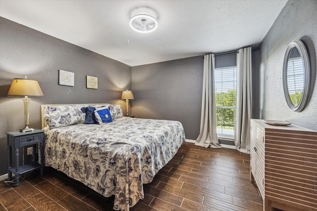 1860 White Oak Dr Unit 246, Houston, TX 77009 - bedroom featuring a textured wall, dark wood-type flooring, baseboards, and a textured ceiling