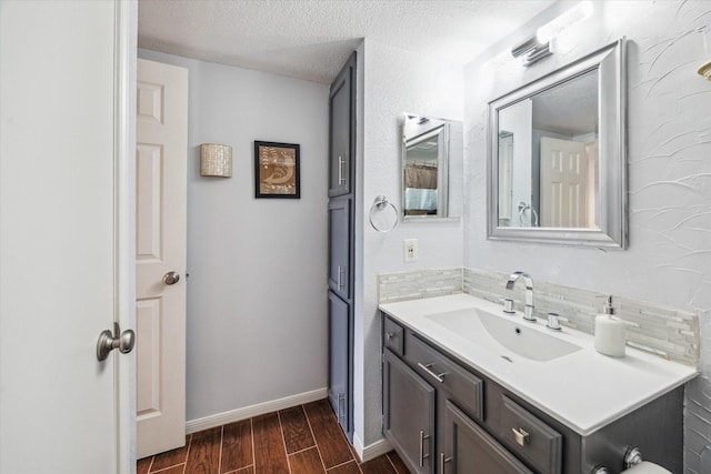 1860 White Oak Dr Unit 246, Houston, TX 77009 - bathroom with wood finished floors, vanity, a textured ceiling, tasteful backsplash, and baseboards