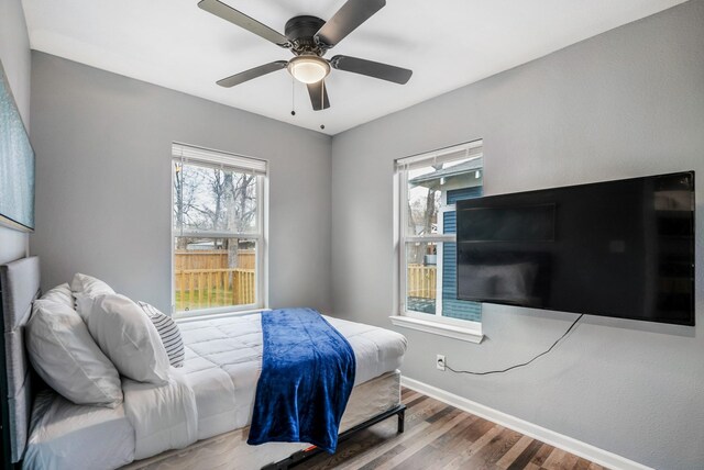 3409 Providence St, Houston, TX 77020 - bedroom featuring wood finished floors, multiple windows, baseboards, and a ceiling fan