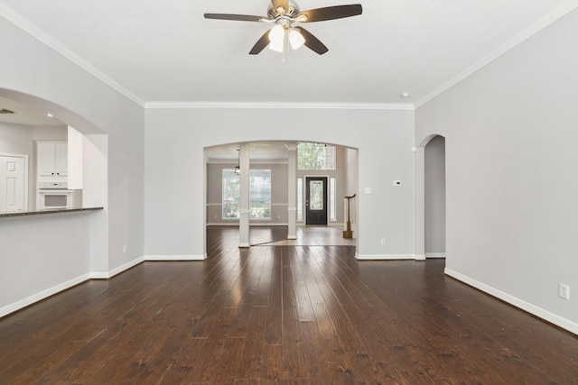2203 Centerbrook Ln, Katy, TX 77450 - unfurnished living room featuring ornamental molding, ceiling fan, dark wood-type flooring, baseboards, and arched walkways