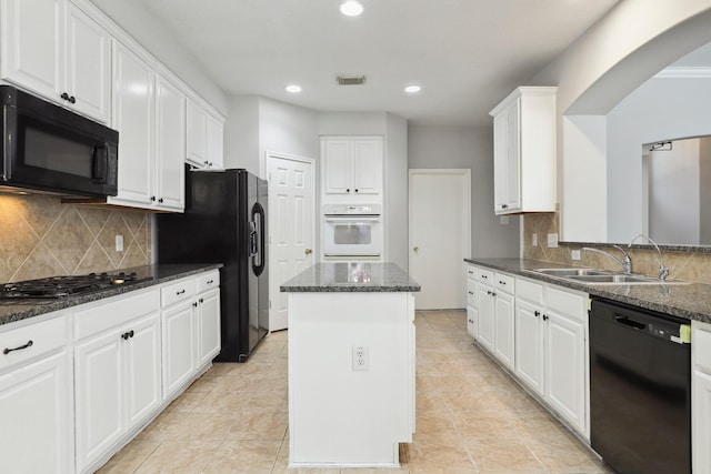 2203 Centerbrook Ln, Katy, TX 77450 - kitchen with black appliances, a sink, arched walkways, white cabinetry, and a center island