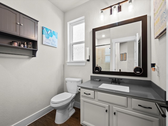 11715 Tranquility Summit Dr, Cypress, TX 77433 - full bathroom with baseboards, wood finished floors, toilet, vanity, and a tile shower
