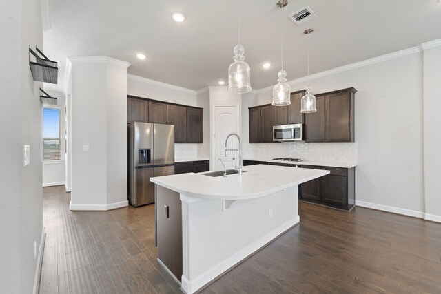 11909 Eastgrove Park Way, Houston, TX 77051 - kitchen featuring stainless steel appliances, a sink, dark brown cabinetry, tasteful backsplash, and an island with sink