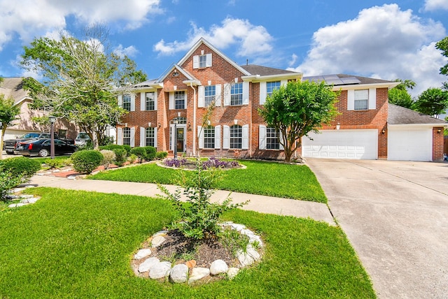 19711 Arbor Creek Dr, Katy, TX 77449 - colonial inspired home featuring brick siding, solar panels, concrete driveway, a front yard, and a garage