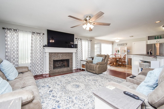 19711 Arbor Creek Dr, Katy, TX 77449 - living area featuring healthy amount of natural light, a ceiling fan, wood finished floors, and a fireplace