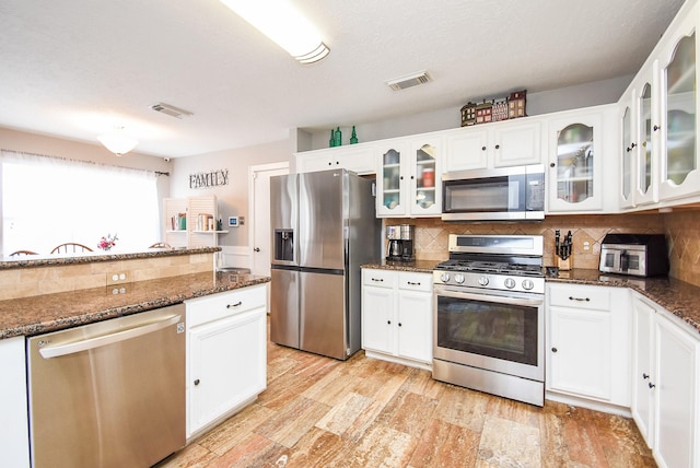 19711 Arbor Creek Dr, Katy, TX 77449 - kitchen with stainless steel appliances, tasteful backsplash, and white cabinetry