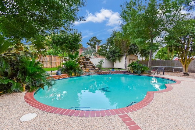 19711 Arbor Creek Dr, Katy, TX 77449 - view of pool featuring a fenced backyard, a storage shed, and an outbuilding