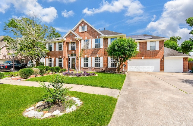 19711 Arbor Creek Dr, Katy, TX 77449 - colonial inspired home featuring brick siding, solar panels, driveway, a front yard, and a garage