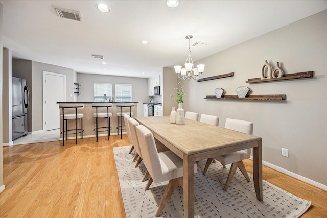 1244 W 18th St, Houston, TX 77008 - dining space featuring light wood finished floors, baseboards, a chandelier, and recessed lighting