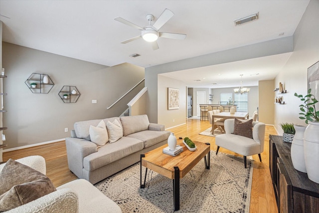 1244 W 18th St, Houston, TX 77008 - living room featuring a chandelier, light wood finished floors, baseboards, and stairs