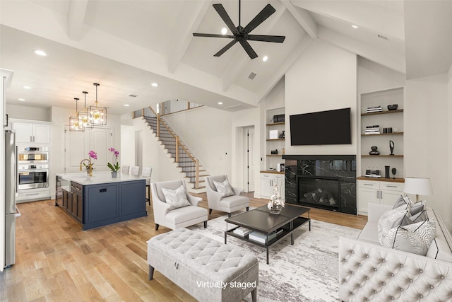1038 W 31st St, Houston, TX 77018 - living room with light wood-style flooring, beamed ceiling, stairway, a ceiling fan, and recessed lighting