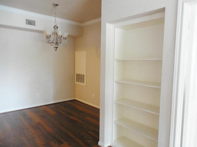 unfurnished dining area featuring crown molding, a chandelier, dark wood-style floors, built in features, and baseboards