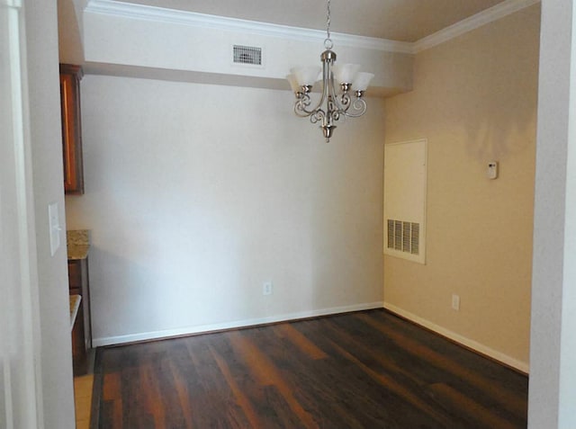 spare room featuring wood finished floors, crown molding, a chandelier, and baseboards