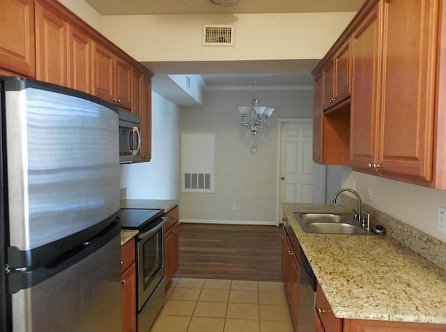 kitchen featuring appliances with stainless steel finishes, a sink, a chandelier, light tile patterned floors, and crown molding