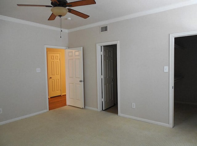 unfurnished bedroom with ornamental molding, carpet flooring, baseboards, and ceiling fan