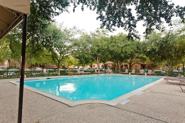 community pool featuring a patio and fence