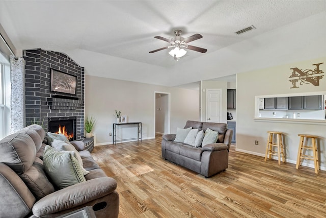 710 Razee Ct, Crosby, TX 77532 - living room with light wood-style floors, a ceiling fan, lofted ceiling, a fireplace, and baseboards
