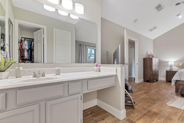 710 Razee Ct, Crosby, TX 77532 - bathroom with lofted ceiling, vanity, wood finished floors, connected bathroom, and baseboards