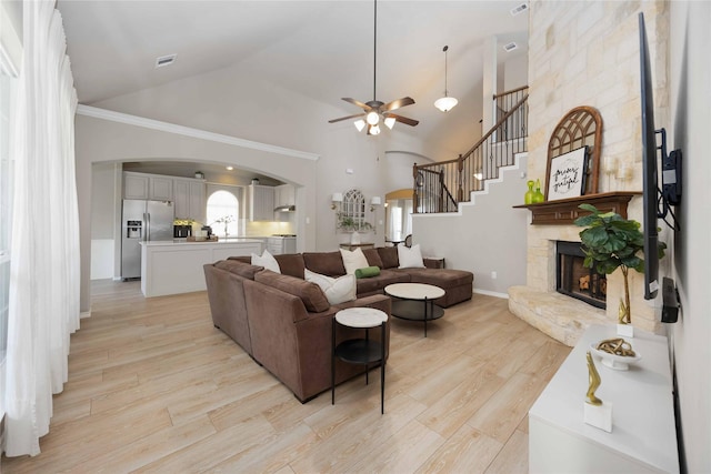 30427 Legacy Pines Dr, Spring, TX 77386 - living area featuring arched walkways, ceiling fan, a fireplace, light wood-style floors, and high vaulted ceiling