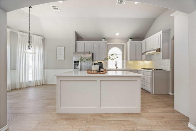 30427 Legacy Pines Dr, Spring, TX 77386 - kitchen featuring appliances with stainless steel finishes, a sink, vaulted ceiling, a center island, and tasteful backsplash