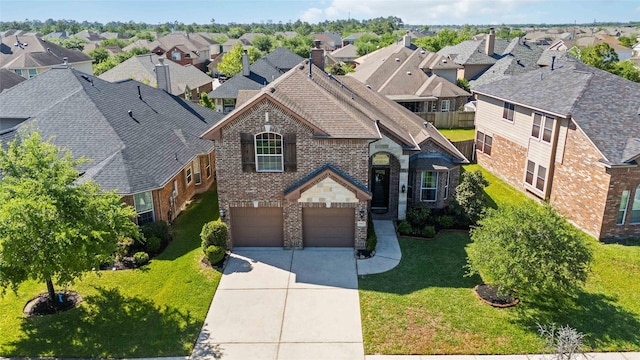 30427 Legacy Pines Dr, Spring, TX 77386 - french country style house featuring brick siding, driveway, a residential view, an attached garage, and a front lawn