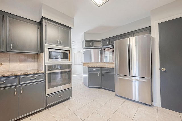5723 Jason St, Houston, TX 77096 - kitchen featuring stainless steel appliances, light tile patterned floors, tasteful backsplash, and light stone countertops