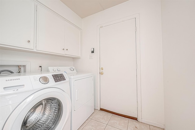 5723 Jason St, Houston, TX 77096 - laundry room featuring washer and clothes dryer, cabinet space, and light tile patterned floors