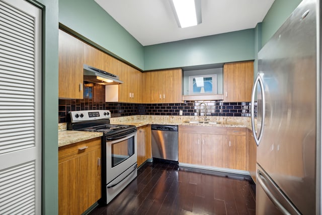 15 Greenway Plz Unit 11A, Houston, TX 77046 - kitchen featuring appliances with stainless steel finishes, under cabinet range hood, light stone countertops, decorative backsplash, and a sink