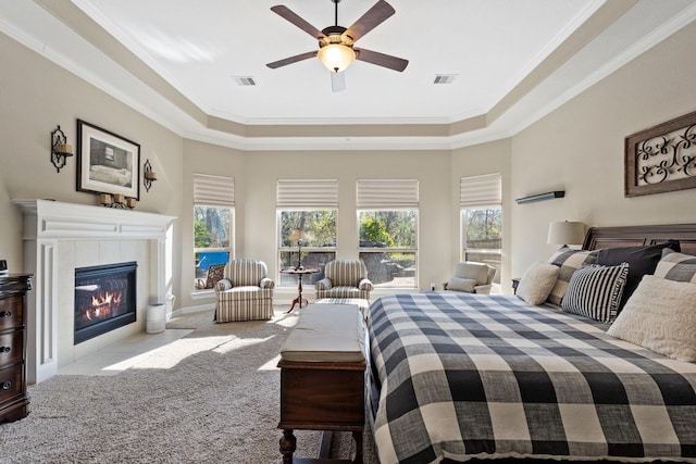 5131 Rowley Falls Ln, Sugar Land, TX 77479 - bedroom with a tray ceiling, ornamental molding, carpet flooring, a tiled fireplace, and a ceiling fan