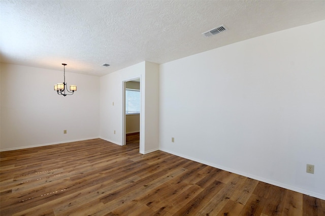 18811 Pine Trace Ct, Humble, TX 77346 - spare room featuring a chandelier, a textured ceiling, wood finished floors, and baseboards