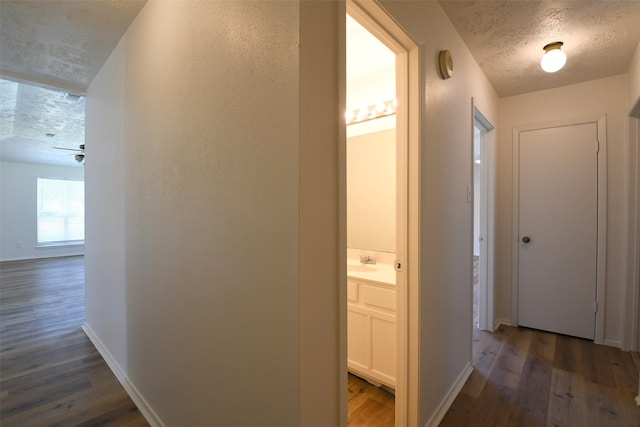 18811 Pine Trace Ct, Humble, TX 77346 - hall with wood finished floors, baseboards, a textured ceiling, and a sink
