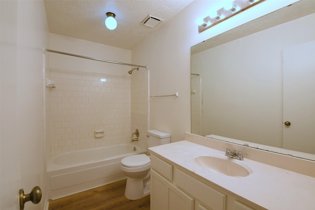 18811 Pine Trace Ct, Humble, TX 77346 - bathroom with wood finished floors, toilet, a textured ceiling, vanity, and washtub / shower combination