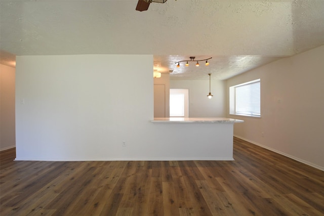 18811 Pine Trace Ct, Humble, TX 77346 - unfurnished room with a textured ceiling, dark wood-style flooring, baseboards, rail lighting, and ceiling fan