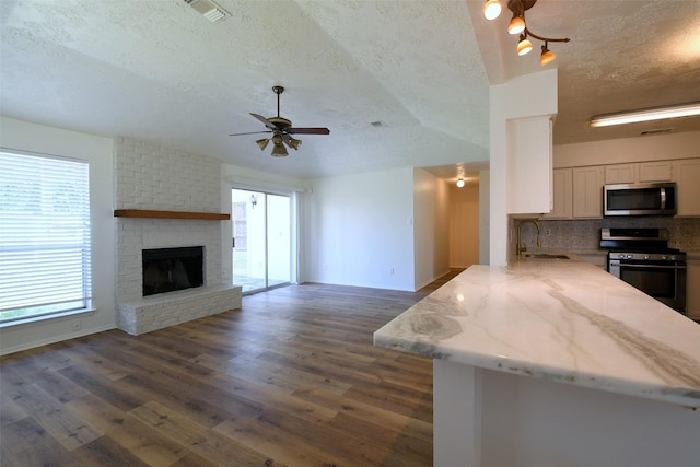 18811 Pine Trace Ct, Humble, TX 77346 - kitchen featuring stainless steel appliances, a textured ceiling, a sink, decorative backsplash, and a peninsula