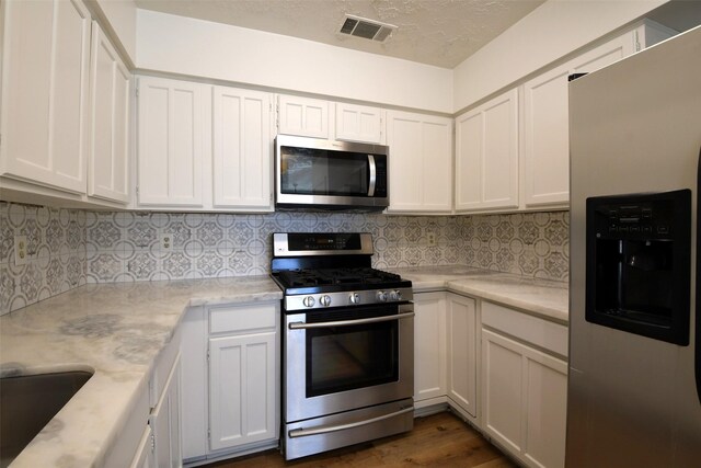 18811 Pine Trace Ct, Humble, TX 77346 - kitchen with appliances with stainless steel finishes, white cabinetry, and backsplash