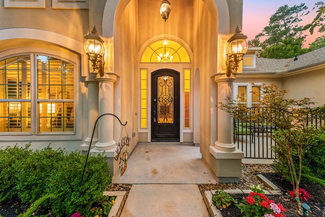 1223 Eversham Way, Kingwood, TX 77339 - exterior entry at dusk featuring stucco siding and covered porch