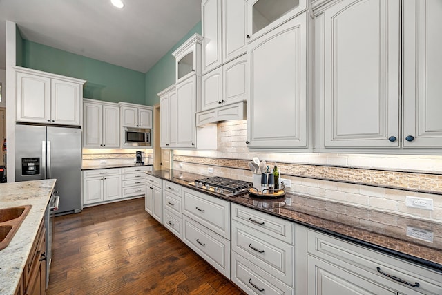 1223 Eversham Way, Kingwood, TX 77339 - kitchen featuring stainless steel appliances, white cabinets, glass insert cabinets, and dark stone countertops