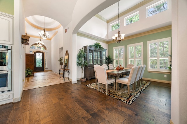 1223 Eversham Way, Kingwood, TX 77339 - dining area featuring a chandelier, a high ceiling, arched walkways, crown molding, and plenty of natural light