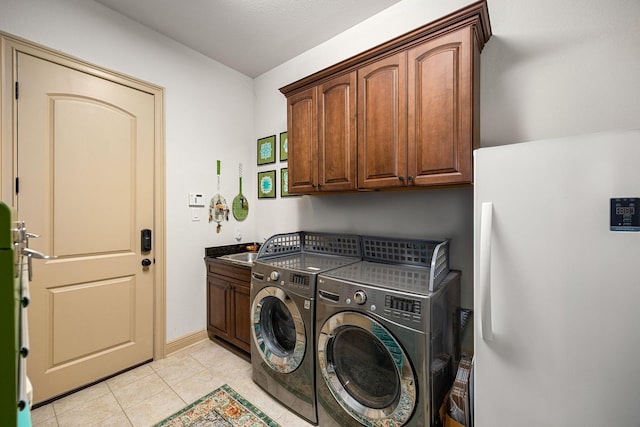 1223 Eversham Way, Kingwood, TX 77339 - washroom with cabinet space, separate washer and dryer, light tile patterned floors, and baseboards