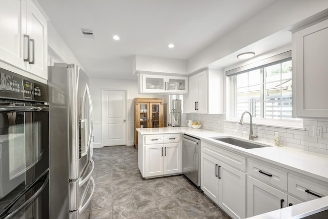 5623 Spellman Rd, Houston, TX 77096 - kitchen with stainless steel appliances, a sink, a peninsula, white cabinets, and recessed lighting