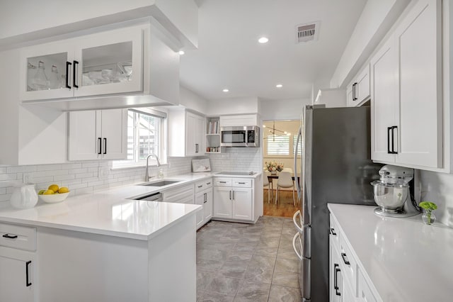 5623 Spellman Rd, Houston, TX 77096 - kitchen with a sink, stainless steel microwave, plenty of natural light, white cabinets, and recessed lighting
