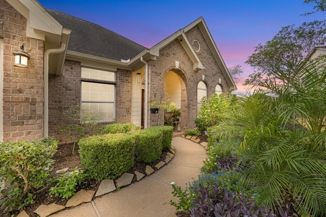 7903 Black Horse Cv, Missouri City, TX 77459 - exterior entry at dusk featuring brick siding and roof with shingles