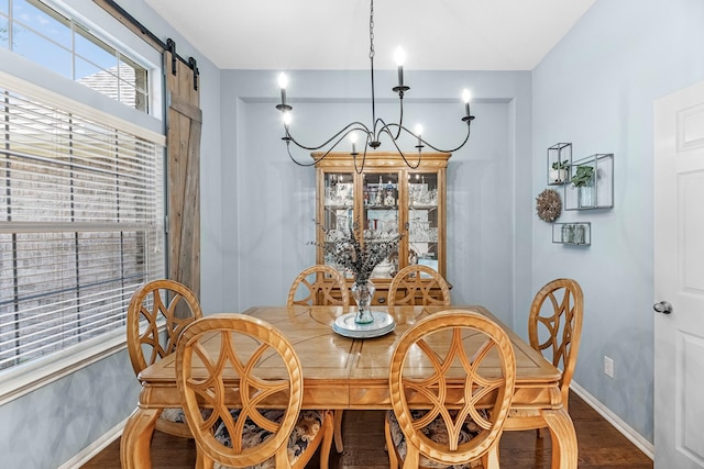 7903 Black Horse Cv, Missouri City, TX 77459 - dining area featuring baseboards, a chandelier, a barn door, and wood finished floors